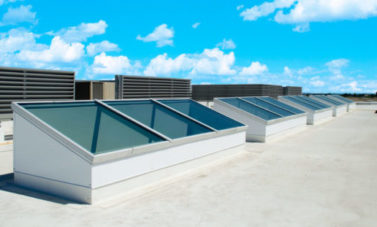 Butted glass skylights on a reflective roof