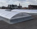Vertical End dome end skylights on a flat roof with a city view