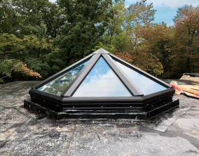 Glass pyramid skylight on a flat roof