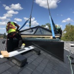 Hoisting a pyramid skylight to the peak of a roof and installing, fall protection