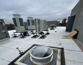 circular skylight with aluminum curb installed on a roof.